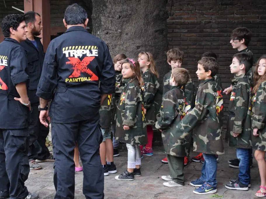 Chicos con chaquetas de combate en fila, con dos coordinadores de TripleX