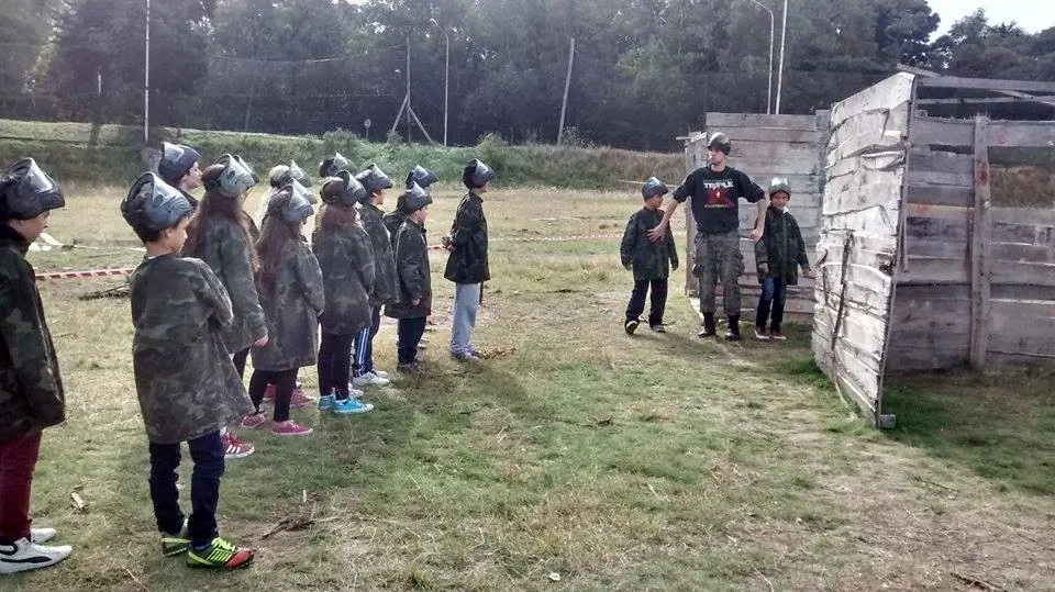 Chicos con máscaras y chaquetas de combate en fila en el escenario Favela